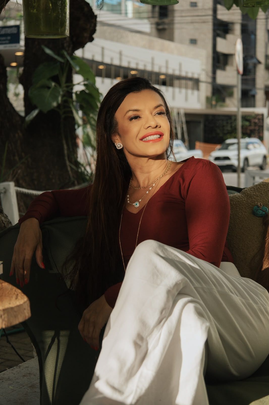 Sandra sorrindo, sentada em uma poltrona